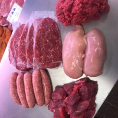various raw meat on stainless steal counter top